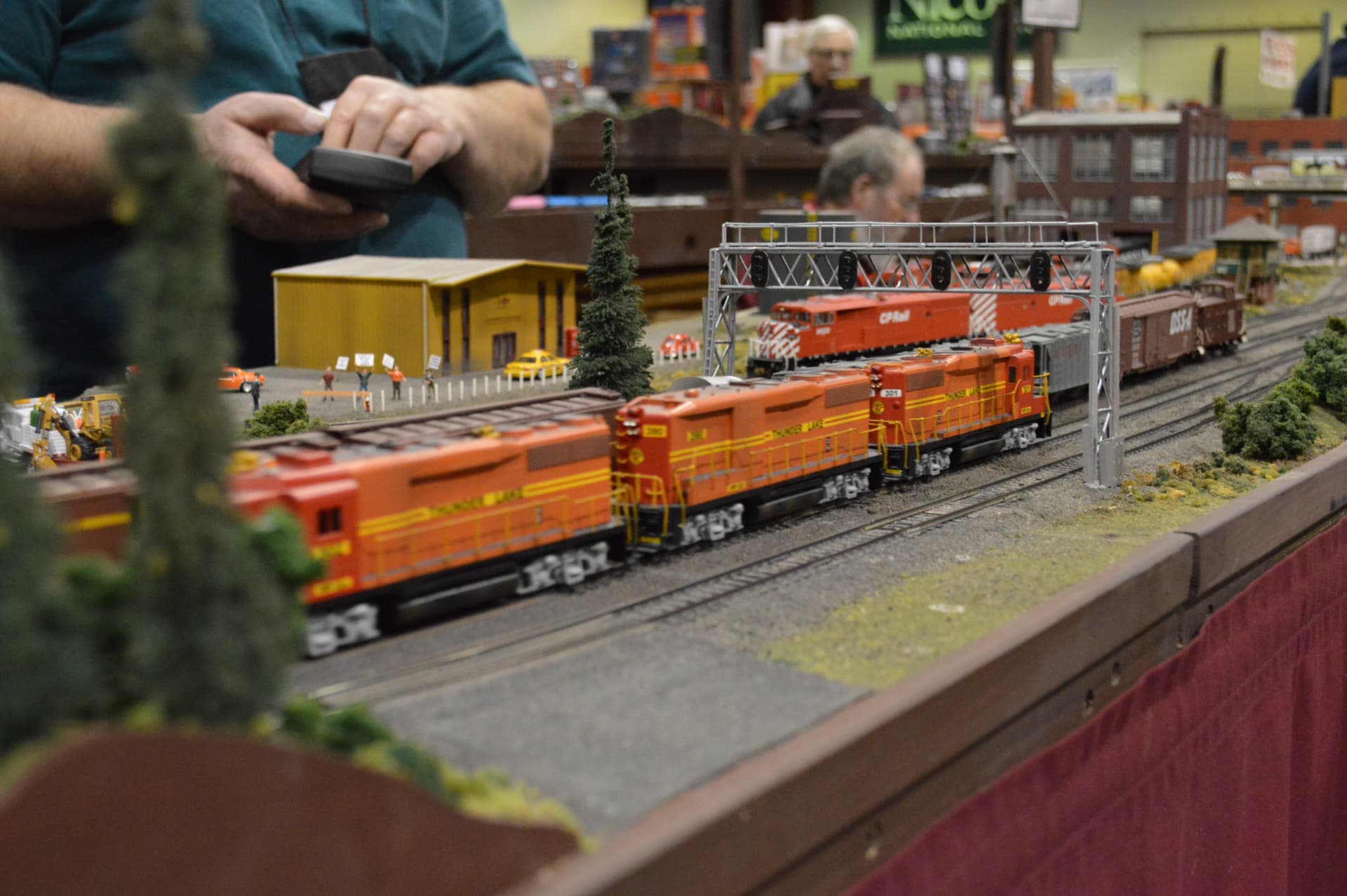 Orange diesel locomotives under signal bridge